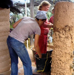 plastering a cob bottle wall- all you need is mud, sand, some straw, prickly pear pad cooking water, and you're ready to go!
